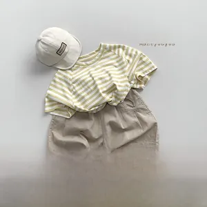 Mise à plat d'un t-shirt rayé jaune avec short en lin et accessoires d'été assortis