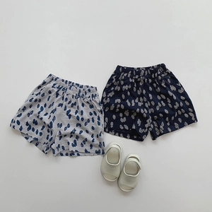 Flat lay of cotton polka dot shorts in blue and grey for kids with casual sandals