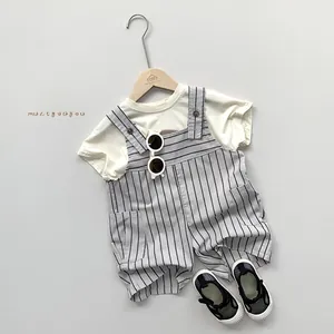 Dettaglio del set salopette a righe per bambini con maglietta e gruccia in legno