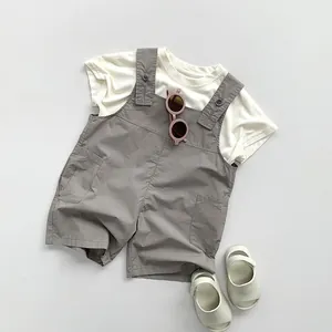 Dettaglio del set salopette bimbo in cotone e lino con maglietta e pantaloncini a bretelle