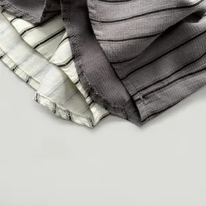 Macro shot of vertical striped cotton-linen fabric with detailed hem stitching on kids' shirt
