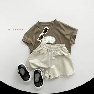 Flat lay of kids Morandi brown t-shirt with CHEESE print and beige elastic shorts