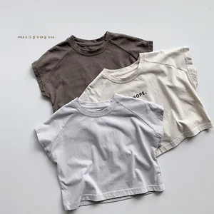 Détail de trois t-shirts en coton pour enfants en marron, beige et gris avec imprimé HOPE