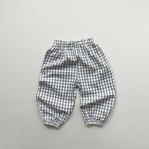 Close-up of kids' high-waist checkered pants featuring elastic cuffs and cotton fabric