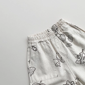 Close-up of cotton linen pants with black botanical prints and elastic waistband detail