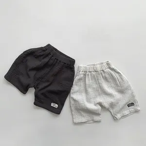 Flat lay of breathable double-layer cotton gauze shorts in grey and beige for toddlers