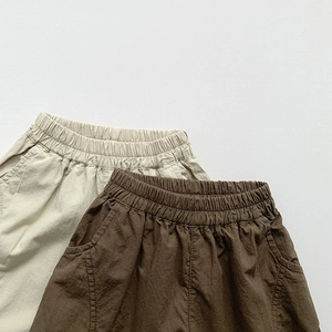 Détail de la taille élastique et de la poche sur un pantalon d'été ample pour enfants