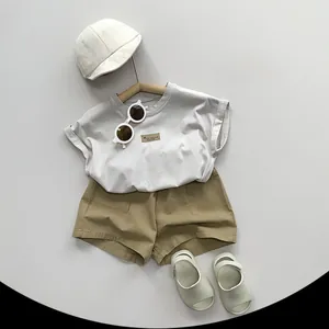 Ensemble t-shirt minimaliste en coton et short kaki posé à plat avec accessoires