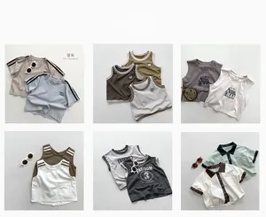 Mise à plat de plusieurs ensembles shorts en maille et t-shirts pour enfants aux tons neutres