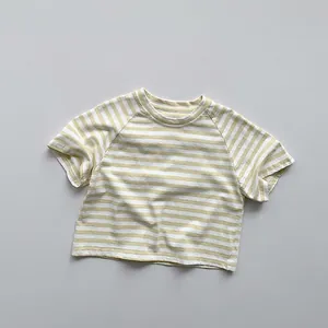 Gros plan d'un t-shirt rayé jaune et blanc en coton pour enfants avec col rond classique
