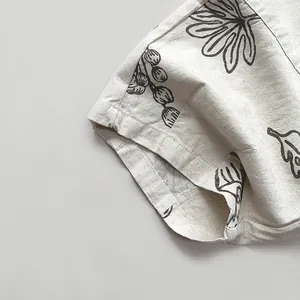 Detailed close-up of natural cotton linen fabric with brown leaf patterns for kids pants