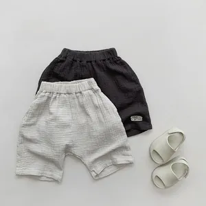 Detail of breathable double-layer cotton gauze kid shorts in charcoal and light grey shades