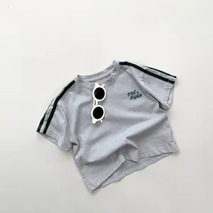 Detail of light gray cotton kids T-shirt featuring green shoulder stripes and THE MOON text