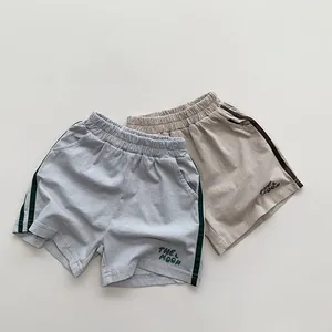 Détail de lot de deux shorts en maille pour enfants avec rayures et broderie THE MOON