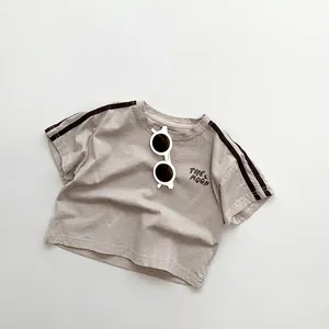 Detail of beige cotton kids T-shirt with The Moon print and black shoulder stripes