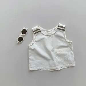 Detail of white linen kids vest with brown striped shoulder pads and a square chest pocket