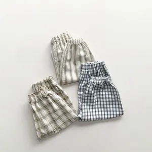 Close-up of three checkered and striped patterns on breathable cotton kid's summer pants