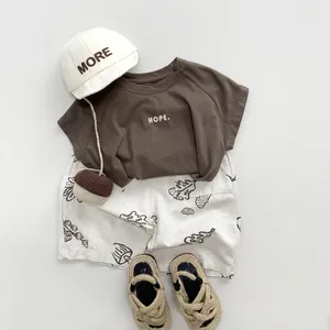Tenue d'été minimaliste pour enfants avec t-shirt marron foncé et short blanc à fleurs