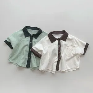 Detailed view of color-block kids short-sleeved shirts with cotton linen texture and buttons