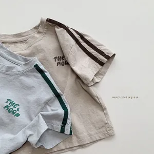 Close-up of cotton kids' t-shirts with The Moon print and striped short sleeves