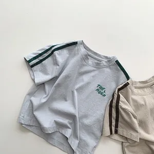 Close-up of kids' cotton t-shirts with The Moon embroidery and striped sleeve details