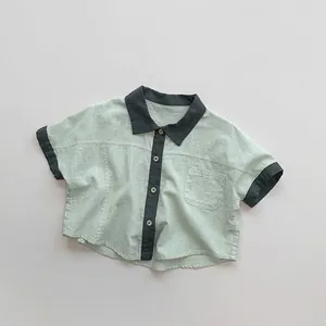 Close-up of mint green cotton linen kids shirt with dark grey contrasting collar and pocket