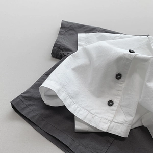 Close-up of minimalist cotton linen shirts showing fabric texture and button detail
