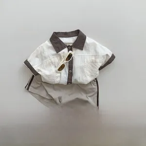 Flat lay of a Korean style kids color-block short sleeve shirt with khaki shorts and sandals