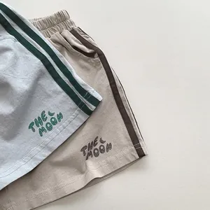 Gros plan sur un short en tricot pour enfant avec bandes latérales et motif lune imprimé