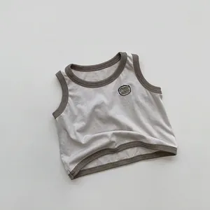Détail du débardeur enfant gris avec bordure vert olive et broderie Just Now