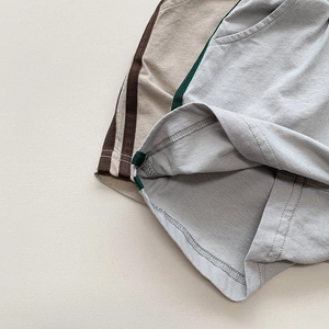Gros plan du short en tricot pour enfants montrant les coutures d'ourlet et poches rayées