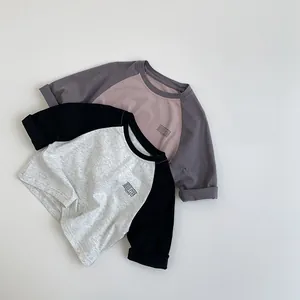 Detalle de camisetas de algodón con mangas raglán en colores contrastados y logo minimalista