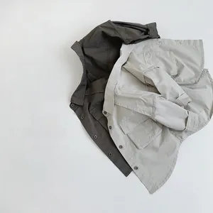 Detailed close-up of cotton long-sleeve shirts in dark grey and beige with utility pockets