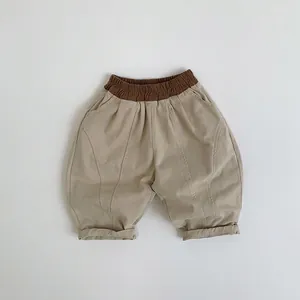 Détail du pantalon lanterne beige pour enfants avec taille élastique marron et ourlet