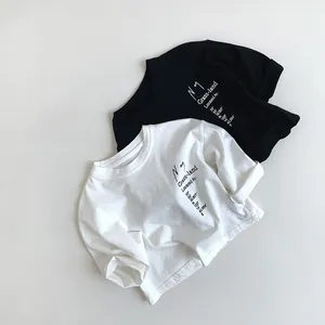 Flat lay of kids' cotton long-sleeve T-shirts with minimal graphic letter prints