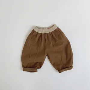 Détail du pantalon marron pour enfants avec taille élastique beige et ourlet revers