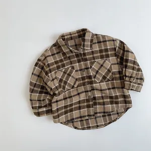 Detailed view of children's vintage brown plaid shirt featuring dual flap pockets and soft fabric