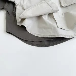 Detail view of double-stitched seams and curved hem on children's cargo shirts
