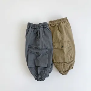 Close-up of boys cargo pants in dark grey and khaki with elastic waist and pockets