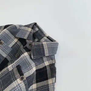 Détails des boutons marron et de la texture à carreaux sur la chemise enfant
