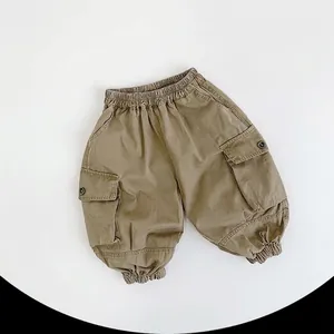 Detail of kids cargo pants showing elastic waistband and large side utility pockets