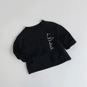 Detail view of cotton kids long sleeve tee with white Grassland text and coordinates