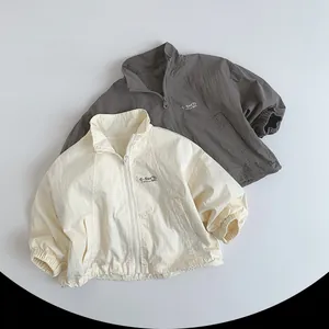 Detail of kids stand-collar windbreaker jackets with elastic cuffs and G-Sun logo
