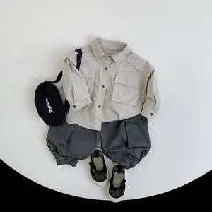 Flat lay of kids outdoor cargo outfit set with khaki shirt and charcoal shorts