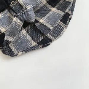 Vue macro d'une chemise à carreaux enfant montrant la texture et l'ourlet arrondi