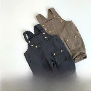 Detail der robusten Baumwoll-Latzhose für Kinder mit Werkzeugtaschen und Metallknöpfen