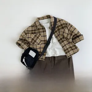 Flat lay of kids vintage plaid shirt set with cargo pants and accessories on white background