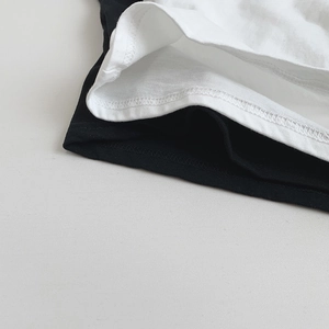 Detailed close-up showing precision double-needle stitching on black and white cotton T-shirt