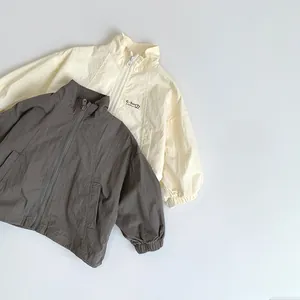 Flat lay of lightweight hooded windbreaker jackets in beige and dark gray colors