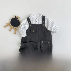 Flachbild von Baby-Herbstoutfit mit gestreiftem Hemd und dunkelgrauer Latzhose